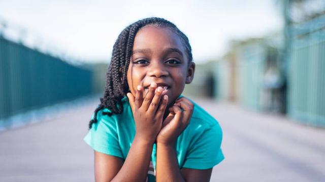 A shy black girl when taking a photo