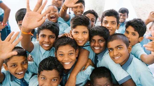 Group of Indian school boys waving their hands and showing excitement