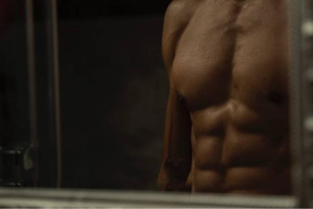 Mirror image of male with six pack body