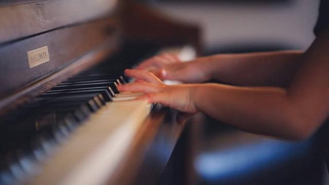 Young pianist playing upright piano